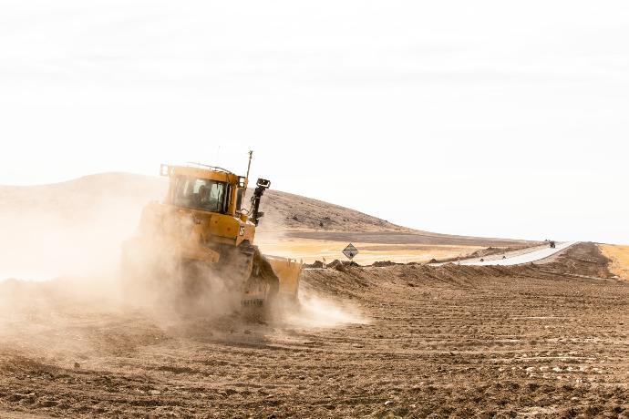 yellow and black heavy equipment on desert during daytime